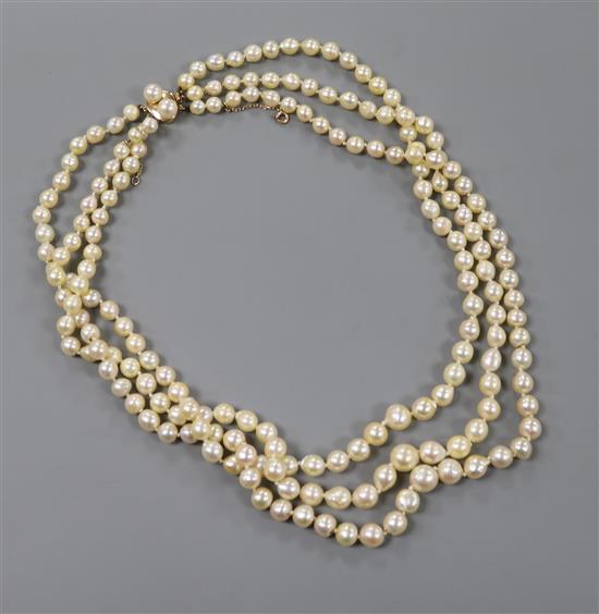 A triple strand baroque cultured pearl necklace, with a yellow metal and twin cultured pearl set clasp, 50cm.